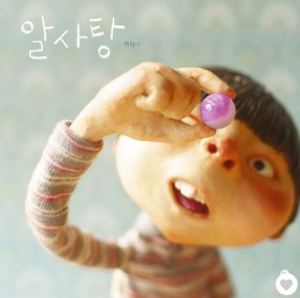 Magic Candy cover shows a boy inspecting a piece of candy - Korean version
