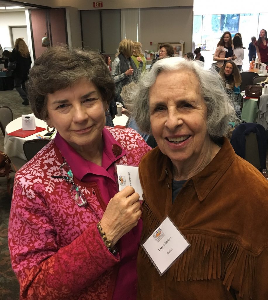 Marilyn Carpenter on left with Tony Johnston on the right smile for the camera at a conference.