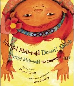 Cover for Marisol McDonald features an upside down girl with red braids and arms hanging down