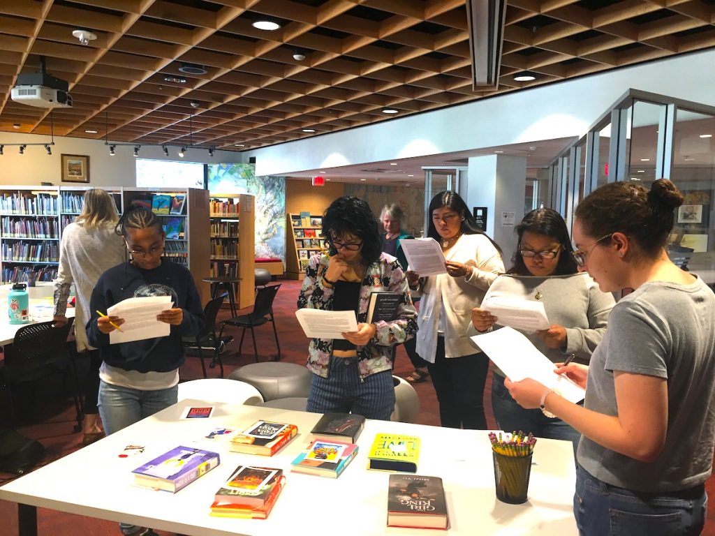 First TRAP book browse. The teen reading ambassadors gather around a table displaying books.