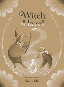A witch holds up a broom to create a cat made of light for a child.