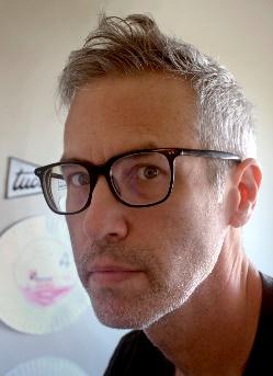 a man with short hair wearing glasses