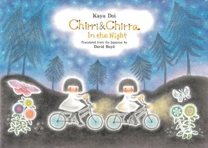 Two young girls who are identical twins ride their bikes through a colorful night.