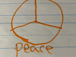 Graffiti board consisting of an orange peace sign with the word peace written under it.